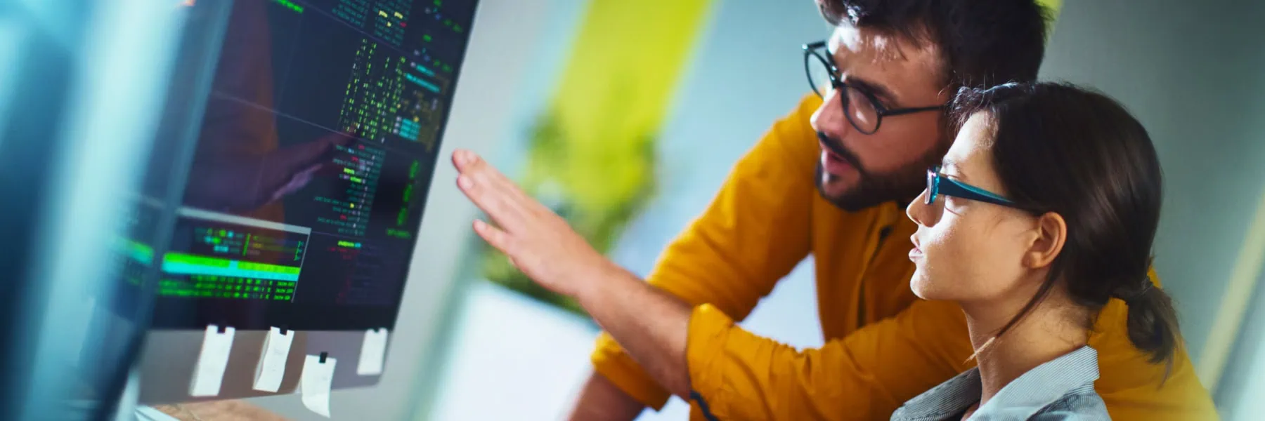 A man and a woman look at a computer screen